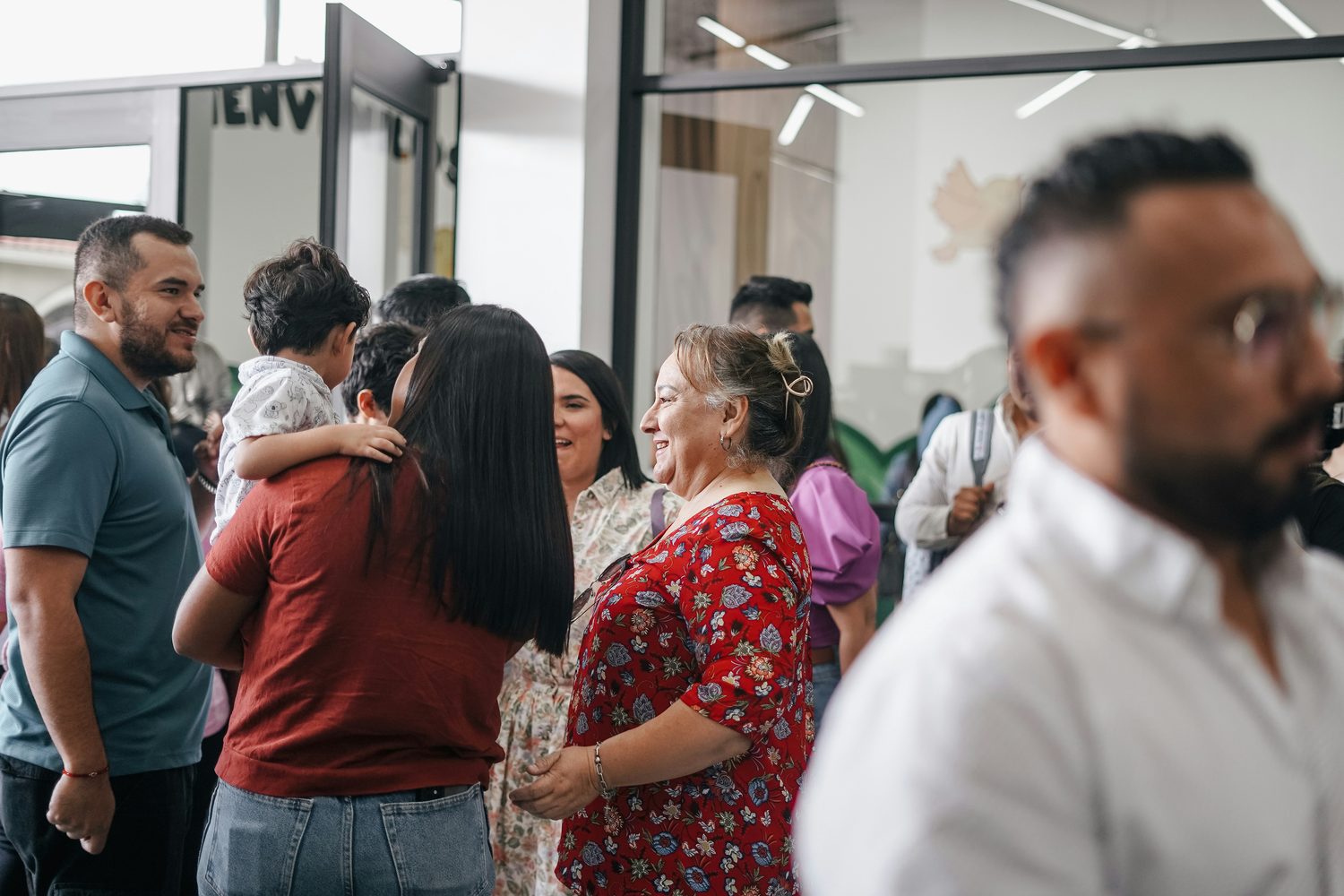 Military families and neighbors talking and laughing at a local community gathering.