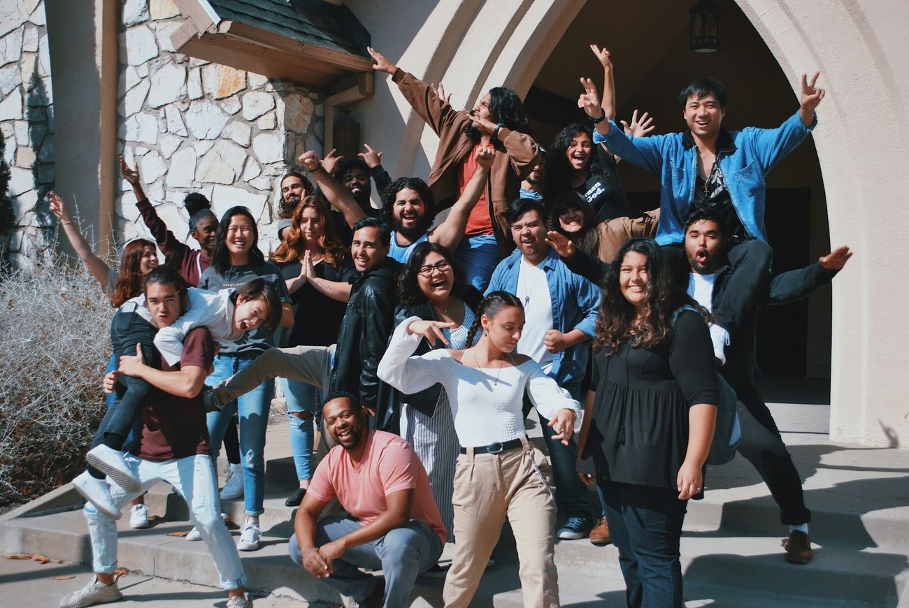 A group of people cheering together with arms raised.