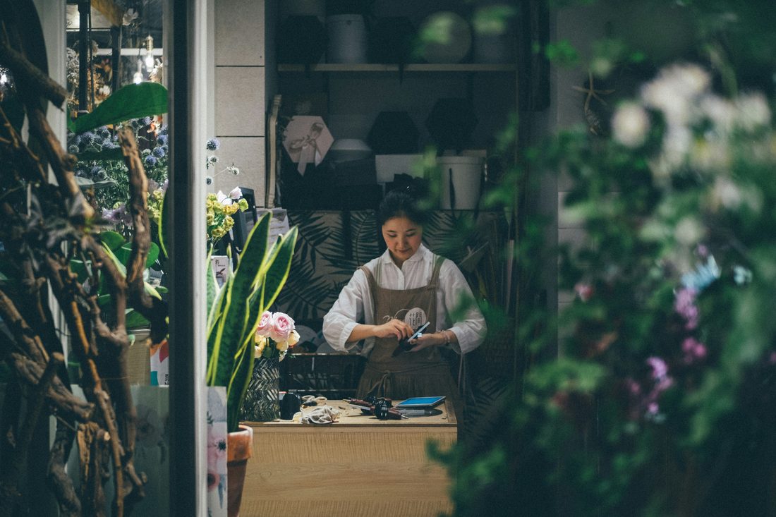 A flower-shop owner arranging blooms in their studio